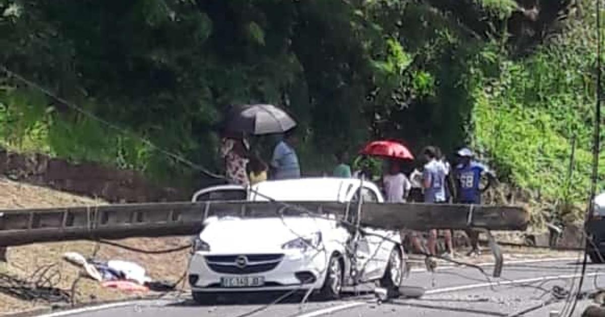 Un poteau électrique écrase une voiture sur la chaussée