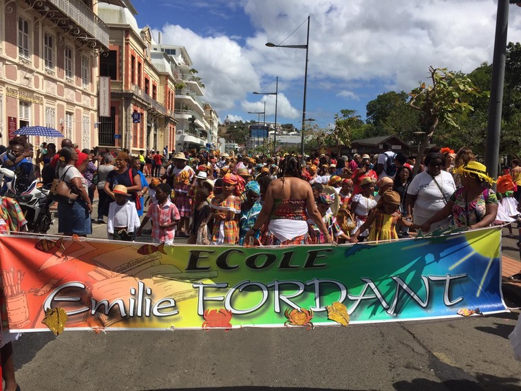 enfants qui défilent derrière une banderole