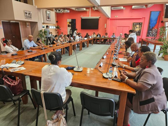 Une trentaine de personnes sont assises autour d'une table