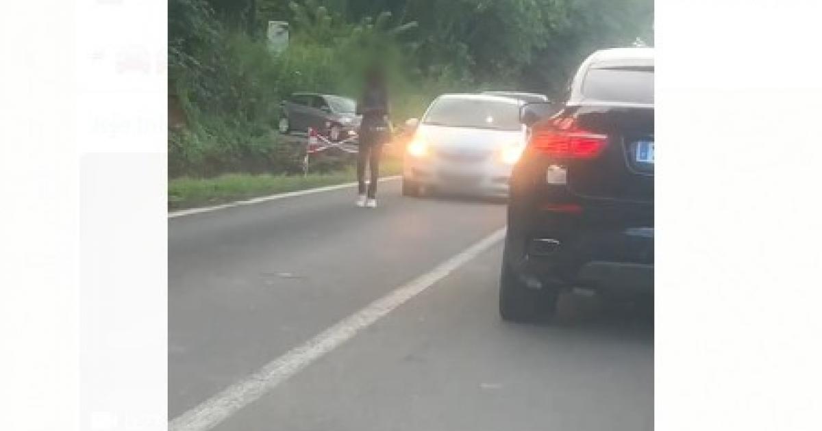 Une personne assise sur la route à Augrain au Robert. Circulation fortement perturbée